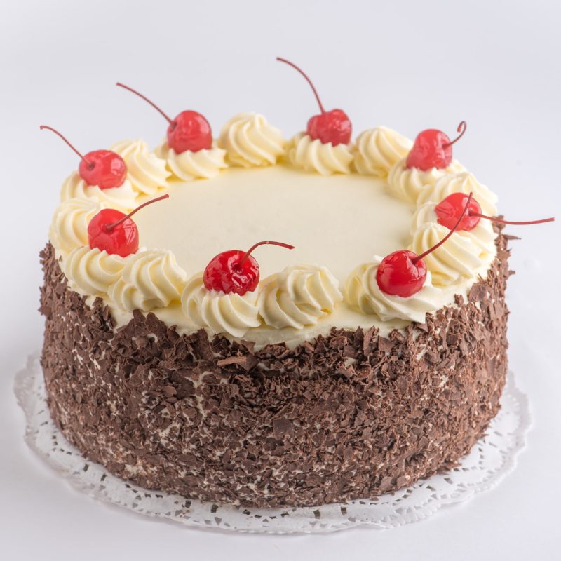 A Black Forrest torta finished with piped cream, chocolate flake and maraschino cherries