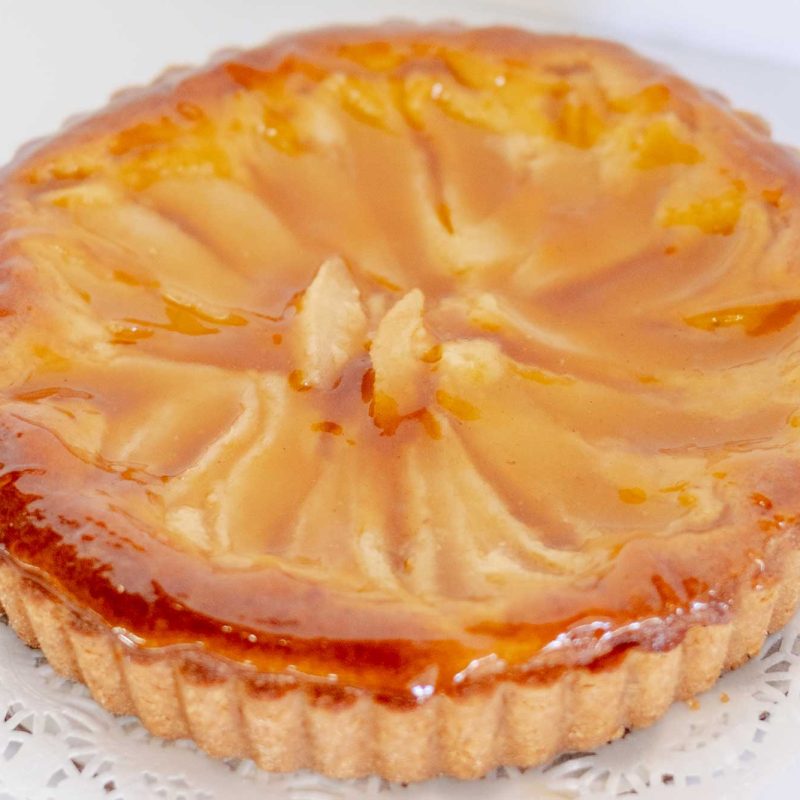 A gluten free pear and almond tart glazed and topped with sliced pear