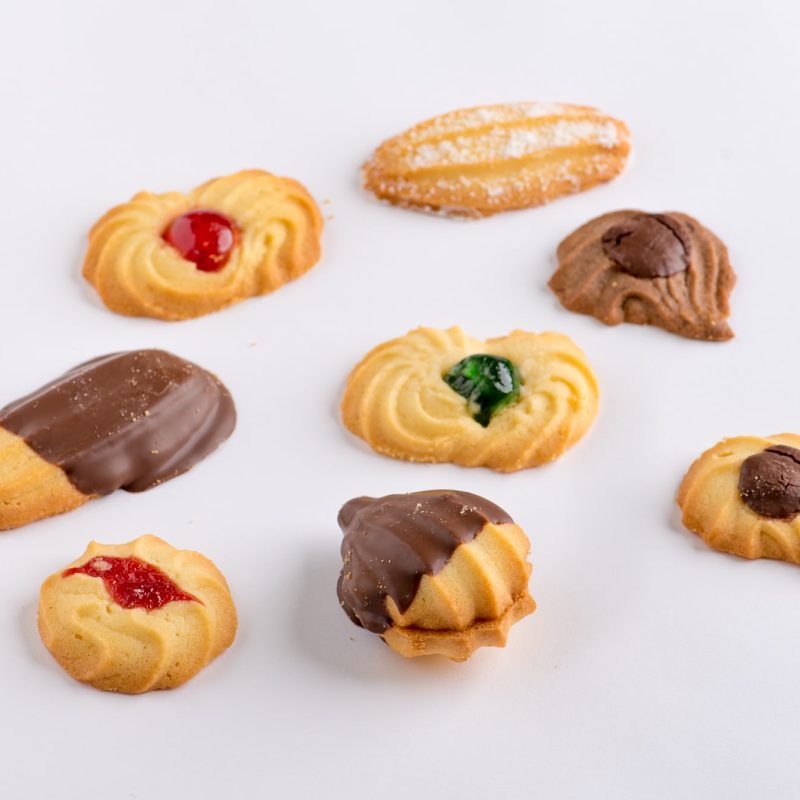 An assortment of Corica shortbread biscuits with jam, chocolate and glacé cherry toppings